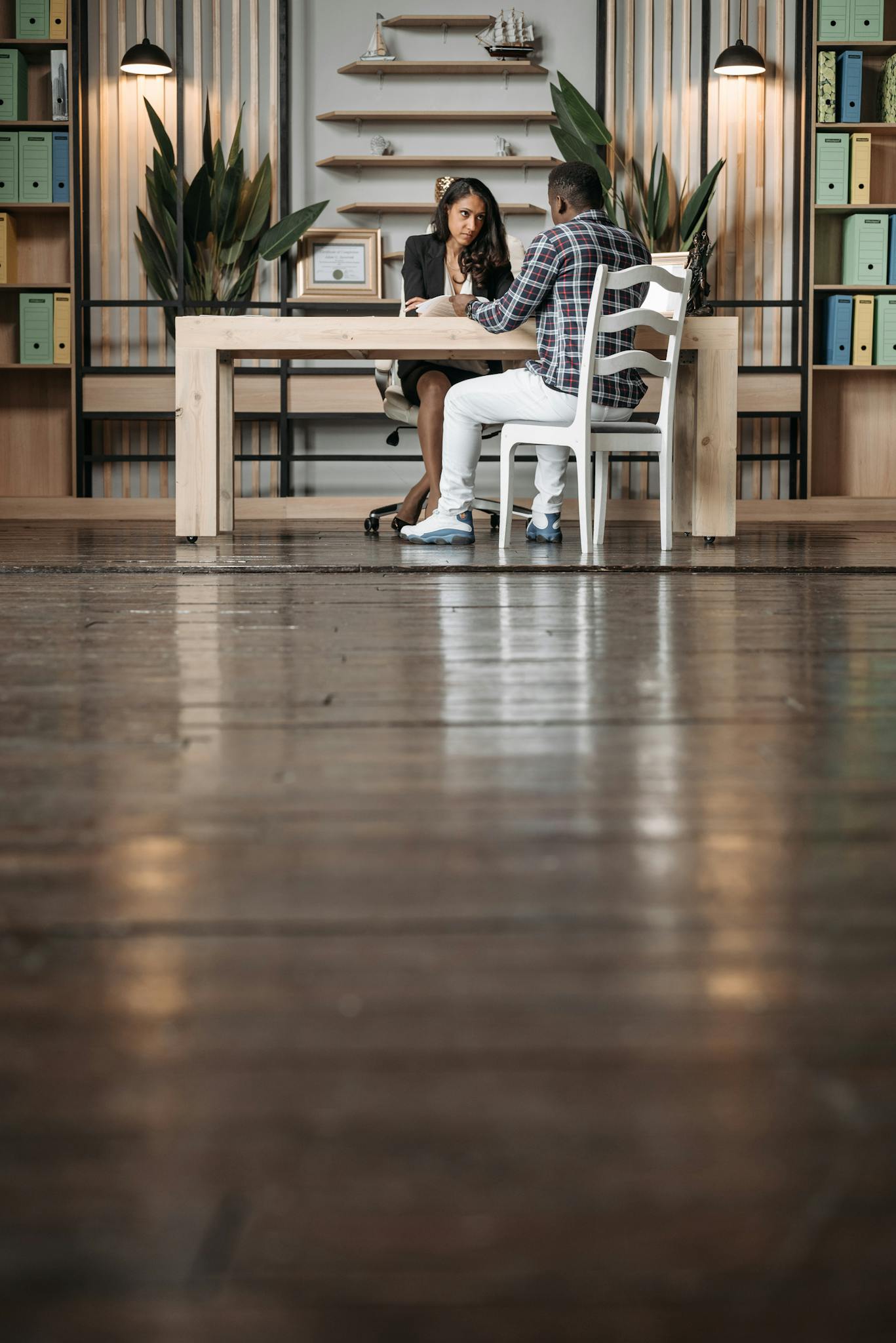 Professional meeting in a stylish office with a wooden table and modern decor.